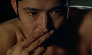 Movie still from “In the Realm of the Senses” (1976), directed by Nagisa Ôshima – A person with his hand to his mouth; Extreme Close Up shot, Low angle