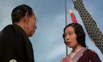 Movie still from “In the Realm of the Senses” (1976), directed by Nagisa Ôshima – An older man standing next to an older woman; Close Up shot, Low angle