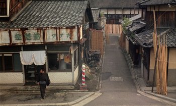 Movie still from “In the Realm of the Senses” (1976), directed by Nagisa Ôshima – A man walking down the street in a small town; Extreme Wide shot, High angle