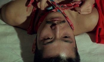 Movie still from “In the Realm of the Senses” (1976), directed by Nagisa Ôshima – A man with a red bandanna around his head; Extreme Close Up shot, Overhead angle