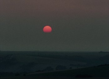 Movie still from “India Song” (1975), directed by Marguerite Duras – A red sun setting in the middle of the night; Extreme Wide shot, Low angle