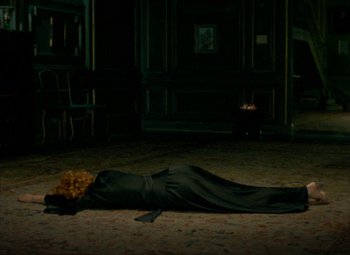 Movie still from “India Song” (1975), directed by Marguerite Duras – A woman in a black dress laying on the floor; Wide shot, High angle