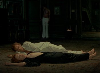 Movie still from “India Song” (1975), directed by Marguerite Duras – A couple of people laying on the ground in a room; Wide shot, High angle