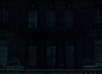 Movie still from “India Song” (1975), directed by Marguerite Duras – A building that has some windows on the outside of it; Extreme Wide shot, Low angle