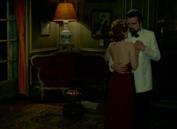 Movie still from “India Song” (1975), directed by Marguerite Duras – A man and a woman dancing in front of a couch; Wide shot, High angle