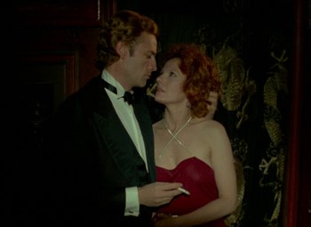 Movie still from “India Song” (1975), directed by Marguerite Duras – A man and a woman in formal wear holding each other; Medium shot, Low angle