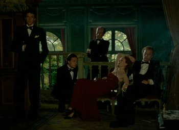 Movie still from “India Song” (1975), directed by Marguerite Duras – A group of people dressed in formal attire; Wide shot, Low angle