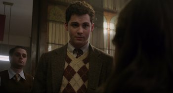 Movie still from “Indignation” (2016), directed by James Schamus – A man in a suit and tie looking at the camera; Medium shot, Over the shoulder angle