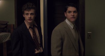 Movie still from “Indignation” (2016), directed by James Schamus – Two young men in suits standing next to each other; Medium shot, Low angle