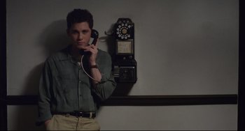 Movie still from “Indignation” (2016), directed by James Schamus – A man holding a phone up to his ear; Medium shot, Low angle