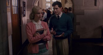 Movie still from “Indignation” (2016), directed by James Schamus – A man and a woman standing next to each other in a hallway; Medium shot, Over the shoulder angle