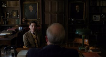 Movie still from “Indignation” (2016), directed by James Schamus – A man sitting in front of a man in a suit and tie; Medium shot, Over the shoulder angle
