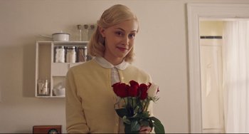 Movie still from “Indignation” (2016), directed by James Schamus – A woman holding a bouquet of roses in a kitchen; Medium shot, Over the shoulder angle
