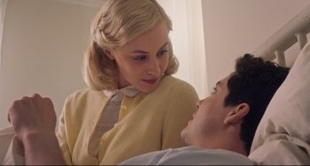 Movie still from “Indignation” (2016), directed by James Schamus – A woman in a yellow dress is looking at a man in a white shirt; Close Up shot, Low angle