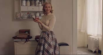 Movie still from “Indignation” (2016), directed by James Schamus – A woman holding a cell phone while standing in a kitchen; Medium shot, Over the shoulder angle