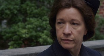 Movie still from “Indignation” (2016), directed by James Schamus – An older woman sitting on a bench looking at the camera; Close Up shot, Over the shoulder angle