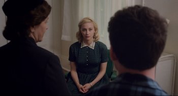 Movie still from “Indignation” (2016), directed by James Schamus – A woman sitting on a chair in front of two other people; Medium shot, Over the shoulder angle