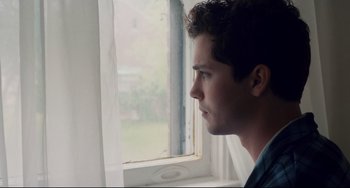 Movie still from “Indignation” (2016), directed by James Schamus – A man looking out of a window at the outside; Close Up shot, Low angle
