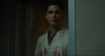 Movie still from “Indignation” (2016), directed by James Schamus – A man in a lab coat standing in front of a window; Close Up shot, Low angle