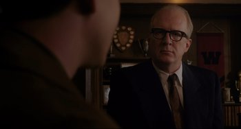 Movie still from “Indignation” (2016), directed by James Schamus – An older man in a suit and tie looking into a mirror; Close Up shot, Over the shoulder angle