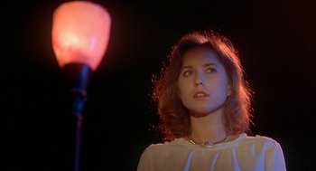 Movie still from “Inferno” (1980), directed by Dario Argento – A woman standing in front of a street light; Close Up shot, Low angle
