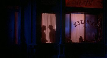 Movie still from “Inferno” (1980), directed by Dario Argento – Two people are standing in a window of a restaurant; Wide shot, Over the shoulder angle