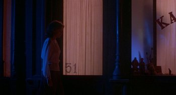 Movie still from “Inferno” (1980), directed by Dario Argento – A woman standing in front of a window at night; Wide shot, Over the shoulder angle