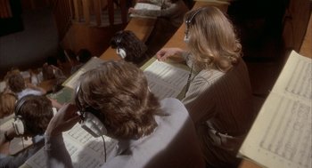 Movie still from “Inferno” (1980), directed by Dario Argento – Two people wearing headphones and looking at music sheets; Medium shot, High angle