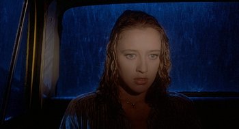 Movie still from “Inferno” (1980), directed by Dario Argento – A woman with wet hair and a black shirt in front of a window; Close Up shot, High angle