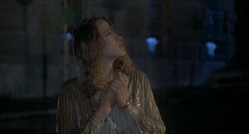 Movie still from “Inferno” (1980), directed by Dario Argento – A woman standing in the rain with her eyes closed; Close Up shot, Low angle
