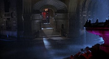 Movie still from “Inferno” (1980), directed by Dario Argento – A man standing in front of an entrance to a building; Extreme Wide shot, High angle