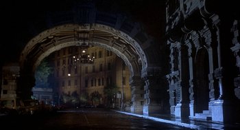 Movie still from “Inferno” (1980), directed by Dario Argento – An archway leading to an ornate building at night; Extreme Wide shot, High angle