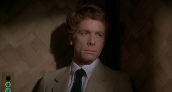 Movie still from “Inferno” (1980), directed by Dario Argento – A person wearing a suit and tie; Close Up shot, Over the shoulder angle