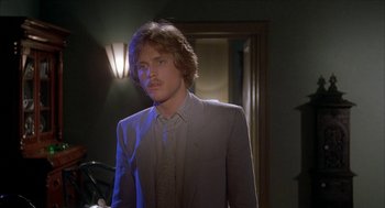 Movie still from “Inferno” (1980), directed by Dario Argento – A man in a suit standing in front of a mirror; Close Up shot, Over the shoulder angle