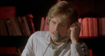 Movie still from “Inferno” (1980), directed by Dario Argento – A man in a white dress shirt and tie talking on a phone; Close Up shot, Low angle