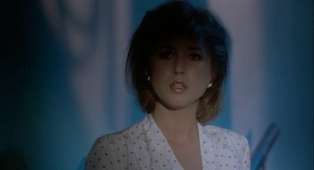 Movie still from “Inferno” (1980), directed by Dario Argento – A woman in a white shirt is looking at the camera; Close Up shot, Low angle