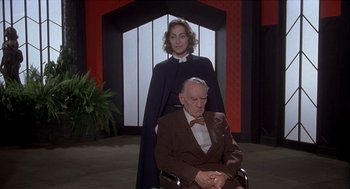 Movie still from “Inferno” (1980), directed by Dario Argento – An older man and a younger woman in a room; Medium shot, High angle