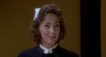 Movie still from “Inferno” (1980), directed by Dario Argento – An older woman wearing a nurse's uniform; Close Up shot, Low angle