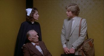 Movie still from “Inferno” (1980), directed by Dario Argento – A group of people standing next to each other in a room; Medium shot, Over the shoulder angle