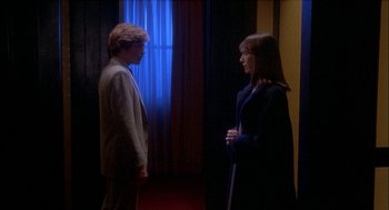 Movie still from “Inferno” (1980), directed by Dario Argento – A man and a woman standing next to each other in front of a window; Medium shot, High angle