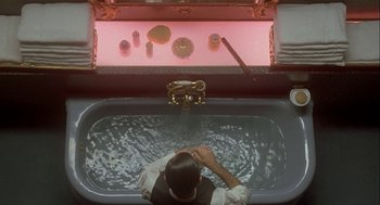 Movie still from “Inferno” (1980), directed by Dario Argento – A man sitting in a bath tub in front of a mirror; Medium shot, Overhead angle