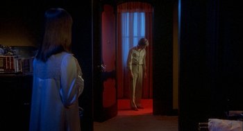 Movie still from “Inferno” (1980), directed by Dario Argento – A man standing in front of a window in a dimly - lit room; Wide shot, High angle