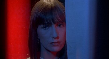 Movie still from “Inferno” (1980), directed by Dario Argento – A woman's face in front of a blue background; Close Up shot, High angle