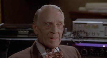 Movie still from “Inferno” (1980), directed by Dario Argento – An older man wearing a suit and a bow tie; Close Up shot, Low angle