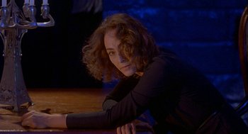 Movie still from “Inferno” (1980), directed by Dario Argento – A woman leaning on a table in front of a wall; Close Up shot, Low angle