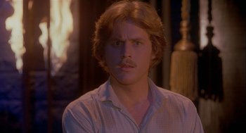 Movie still from “Inferno” (1980), directed by Dario Argento – A man with a beard and a mustache is looking at the camera; Close Up shot, Over the shoulder angle