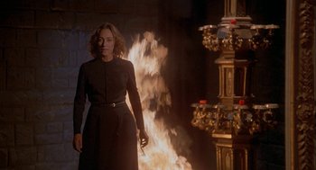 Movie still from “Inferno” (1980), directed by Dario Argento – A woman standing in front of a fire; Medium shot, Low angle