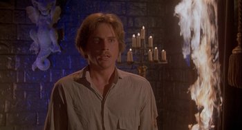 Movie still from “Inferno” (1980), directed by Dario Argento – A man standing in front of a fireplace with candles; Medium shot, Low angle