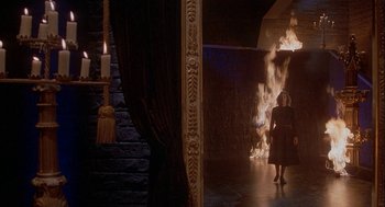 Movie still from “Inferno” (1980), directed by Dario Argento – A woman standing in front of a fireplace; Wide shot, High angle