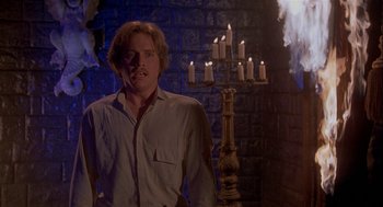 Movie still from “Inferno” (1980), directed by Dario Argento – A man standing in front of a candelabrum; Medium shot, Low angle